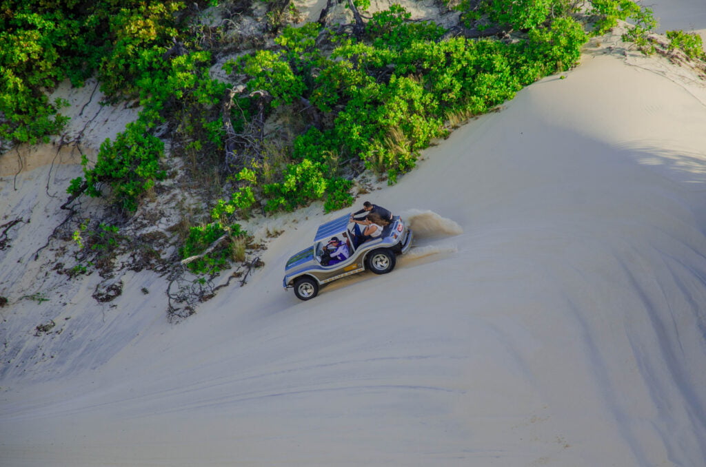 Buggy Cinza Descendo Uma Duna Com Bastante Emoção.